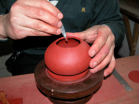 32、用“旁皮刀”挑挟起壶底片，试试是否与壶底圈能恰当的紧密。